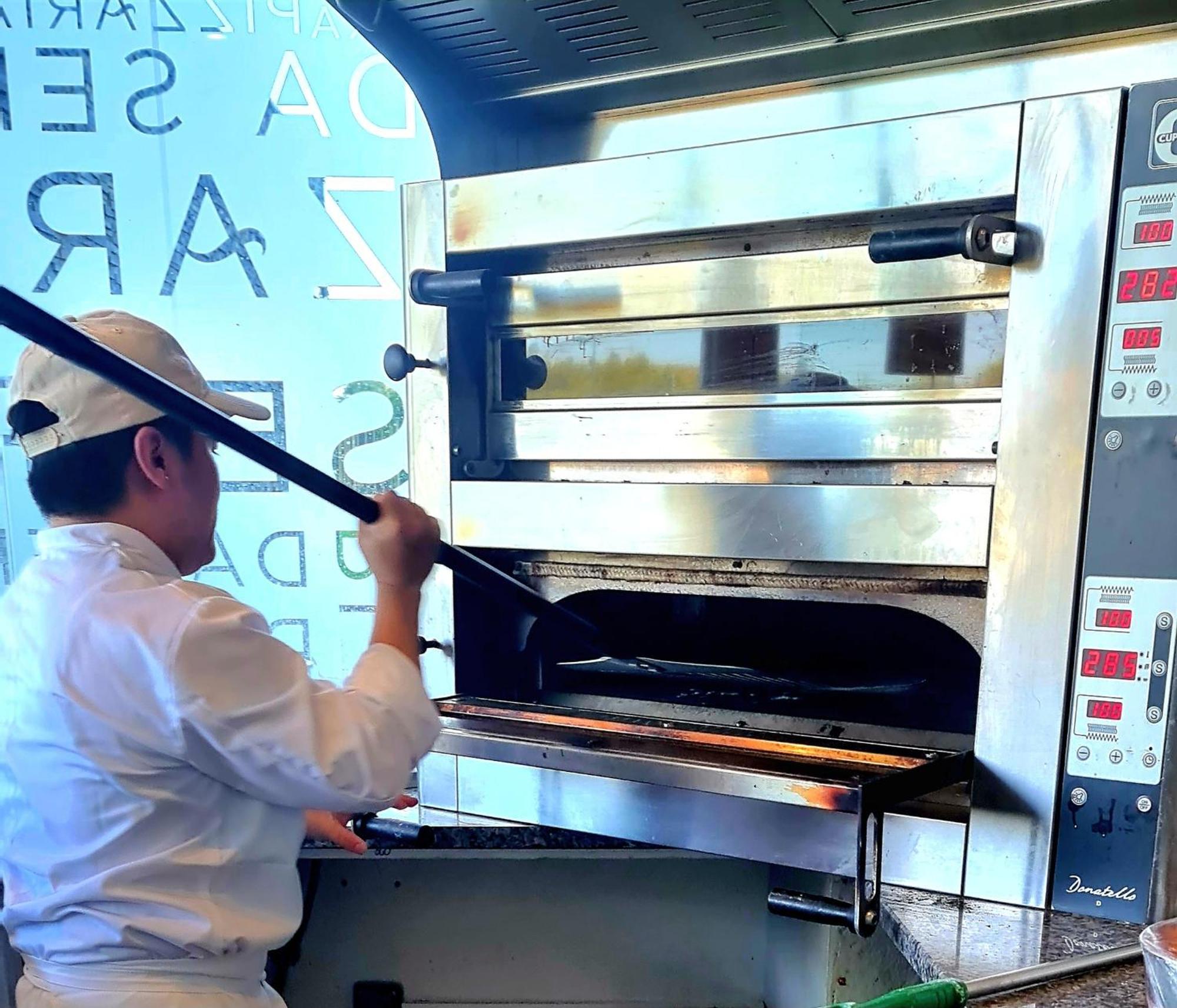 Monchique Resort & Spa Екстер'єр фото A pizzaiolo baking a pizza in a wood-fired oven
